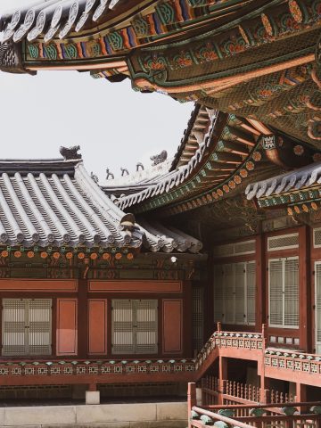 古装题材ai魔改短剧封面，宫墙长廊里人物回眸，暖金色宫灯光晕